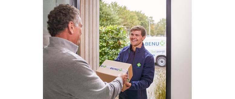 Bezorger van BENU Direct brengt een pakje aan de deur van de klant