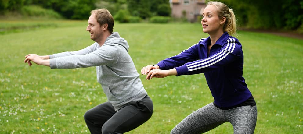 Twee mensen die sporten buiten op het grasveld