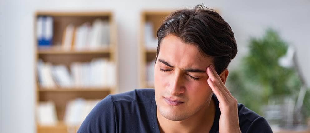 Man heeft zichtbaar last van hoofdpijn.