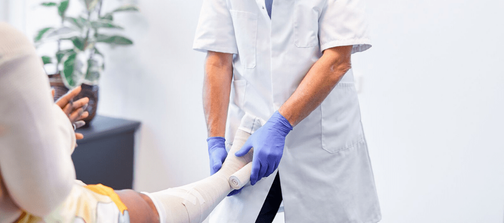 verpleegkundige bindt een been in verband