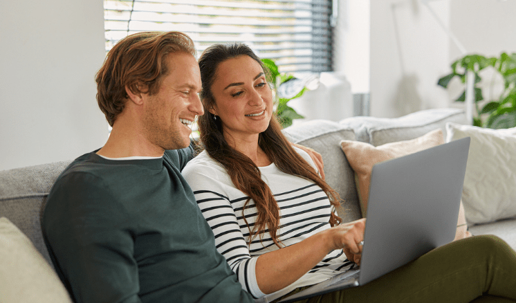 Man en vrouw zitten op de bank met laptop