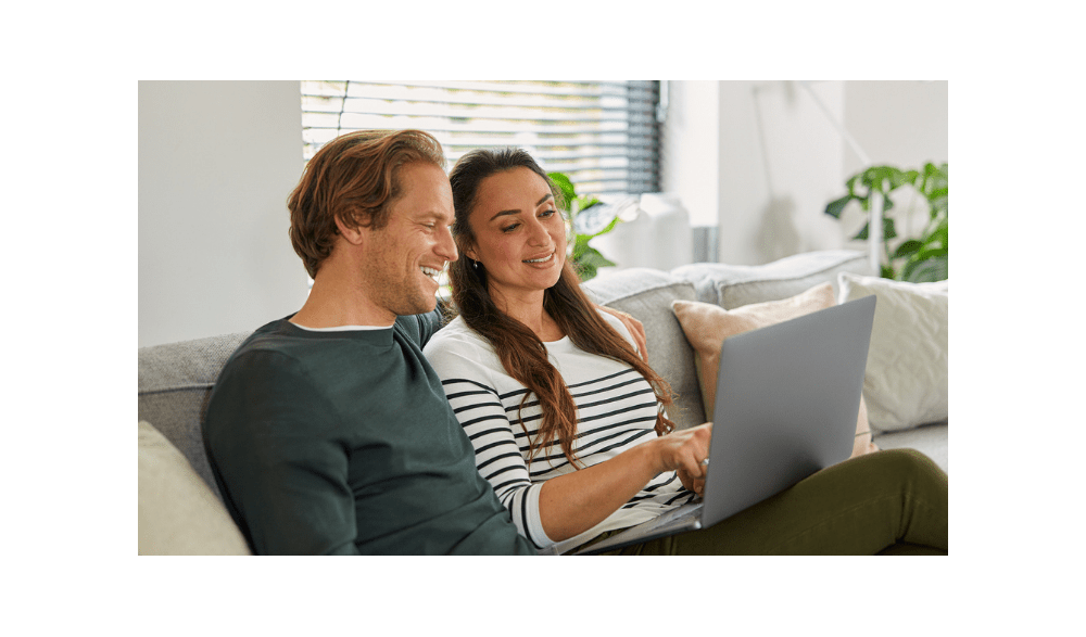 Man en vrouw zitten op de bank met laptop