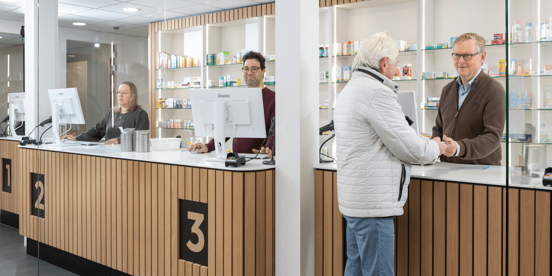 Balie van zelfstandige apotheek met apotheker en cliënt 