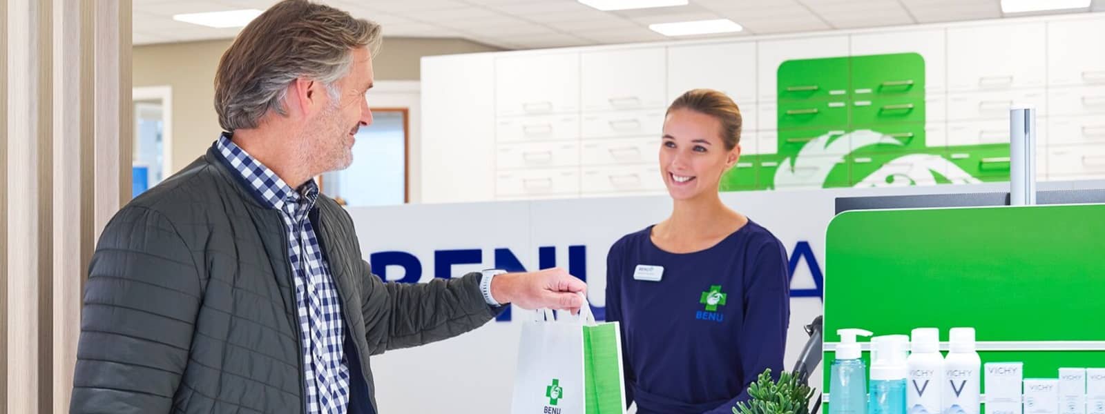 Klant neemt bestelling in ontvangst in apotheek