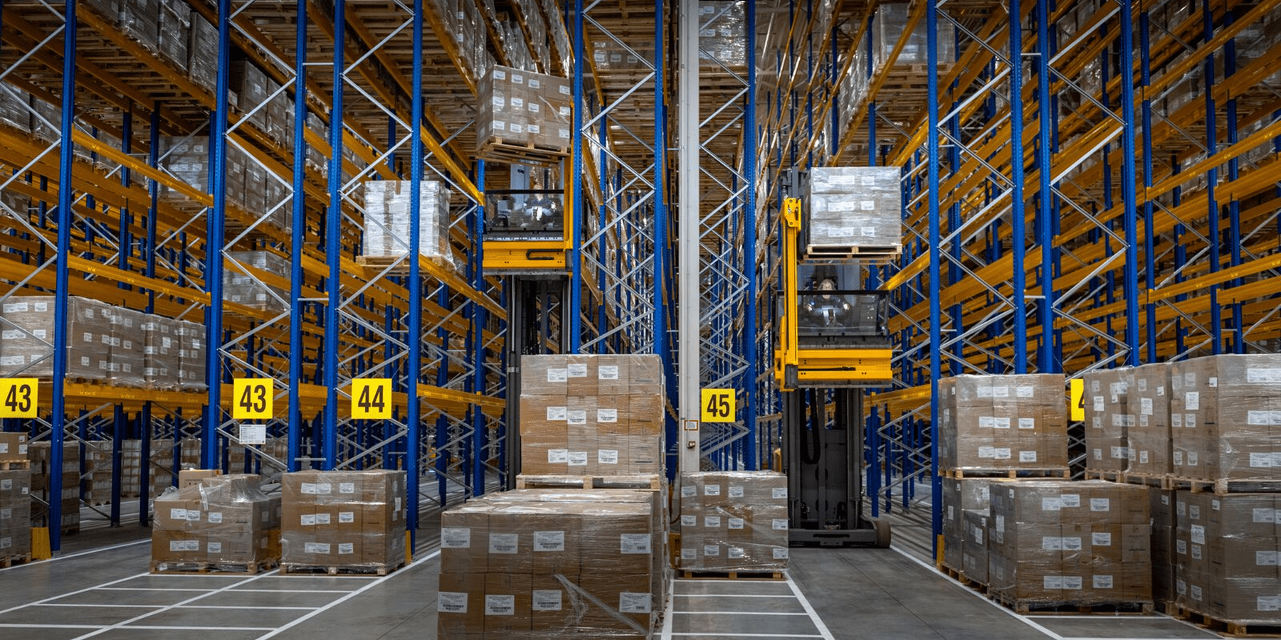 Heftrucks tussen stellingen in warehouse